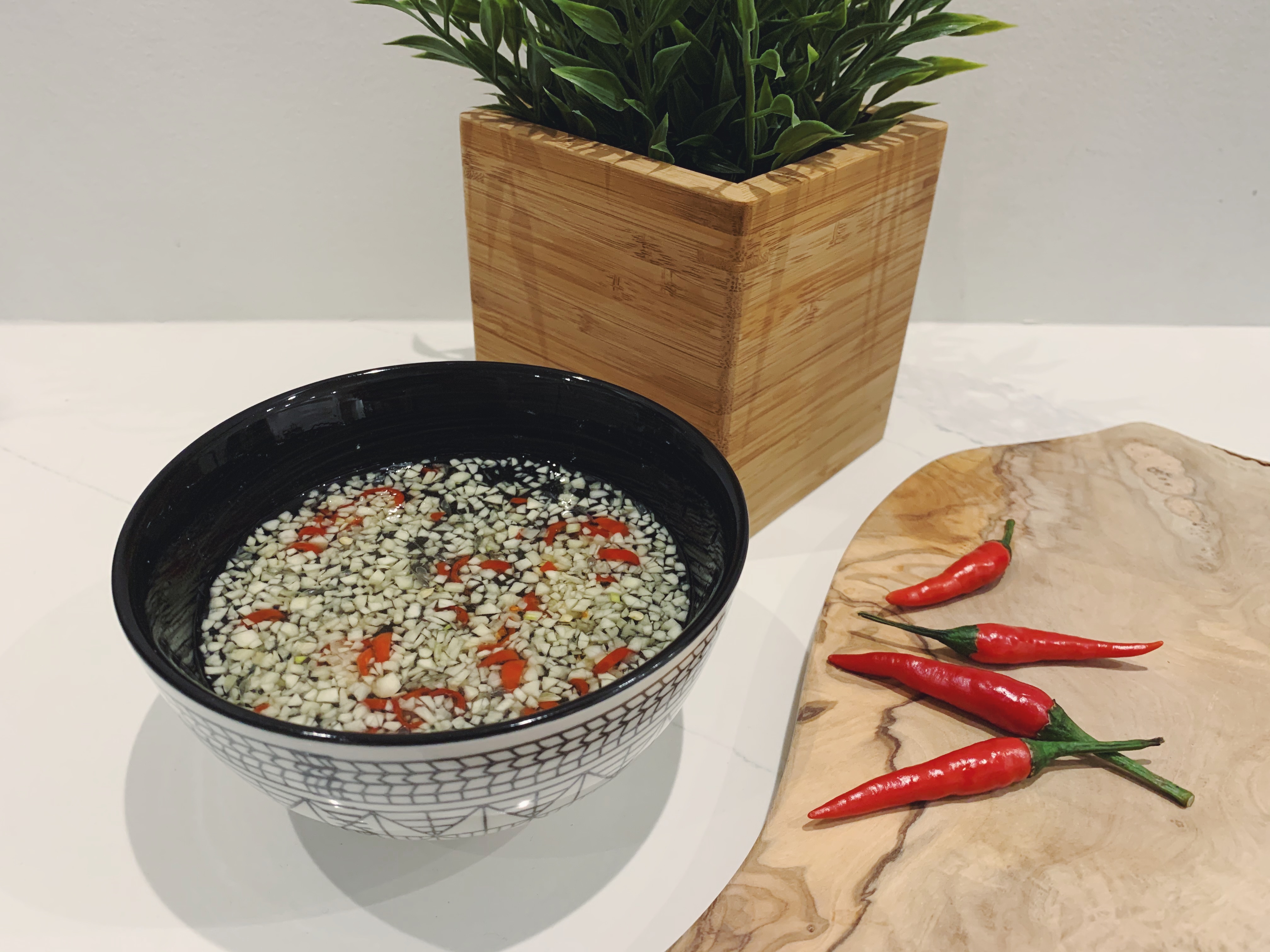 Fish Sauce bowl with chilli beside bamboo flowers